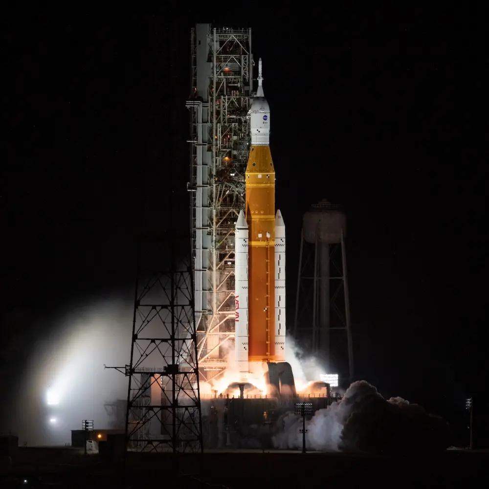 The SLS rocket for Artemis 1 lit up on its launchpad at nighttime